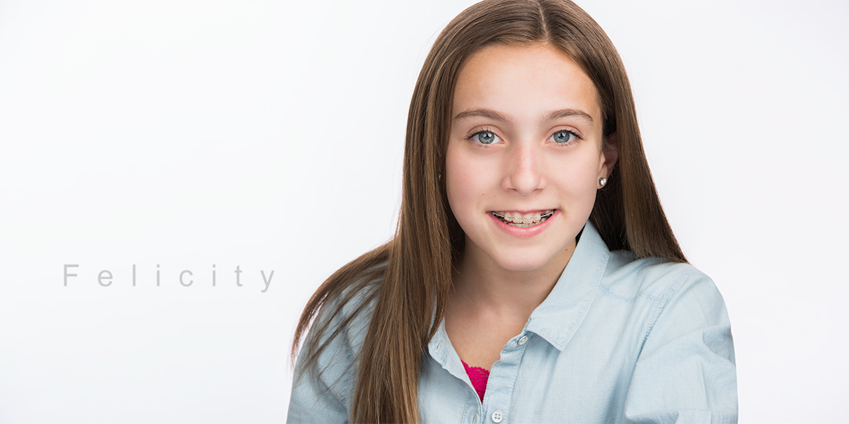 Dark haired Female Actor receives posing instructions from Brian Yungblut at Studio Headshots session on Pure White Backdrop